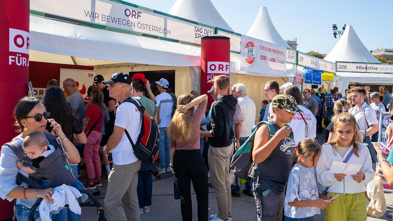 Eine belebte Veranstaltung im Freien mit vielen Menschen, die sich am ORF-Stand „Wir bewegen Österreich“ versammeln. Mehrere Zelte sind zu sehen, und die Besucher:innen erkunden die Stände.