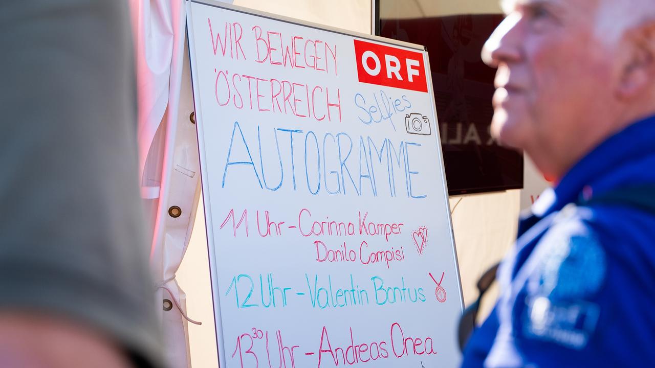 Ein Whiteboard am ORF-Stand, auf dem die Zeiten für Autogramm- und Selfie-Sessions mit Athlet*innen und Promis angekündigt werden: Corinna Kamper und Danilo Campisi, Valentin Bontus, Andreas Onea.